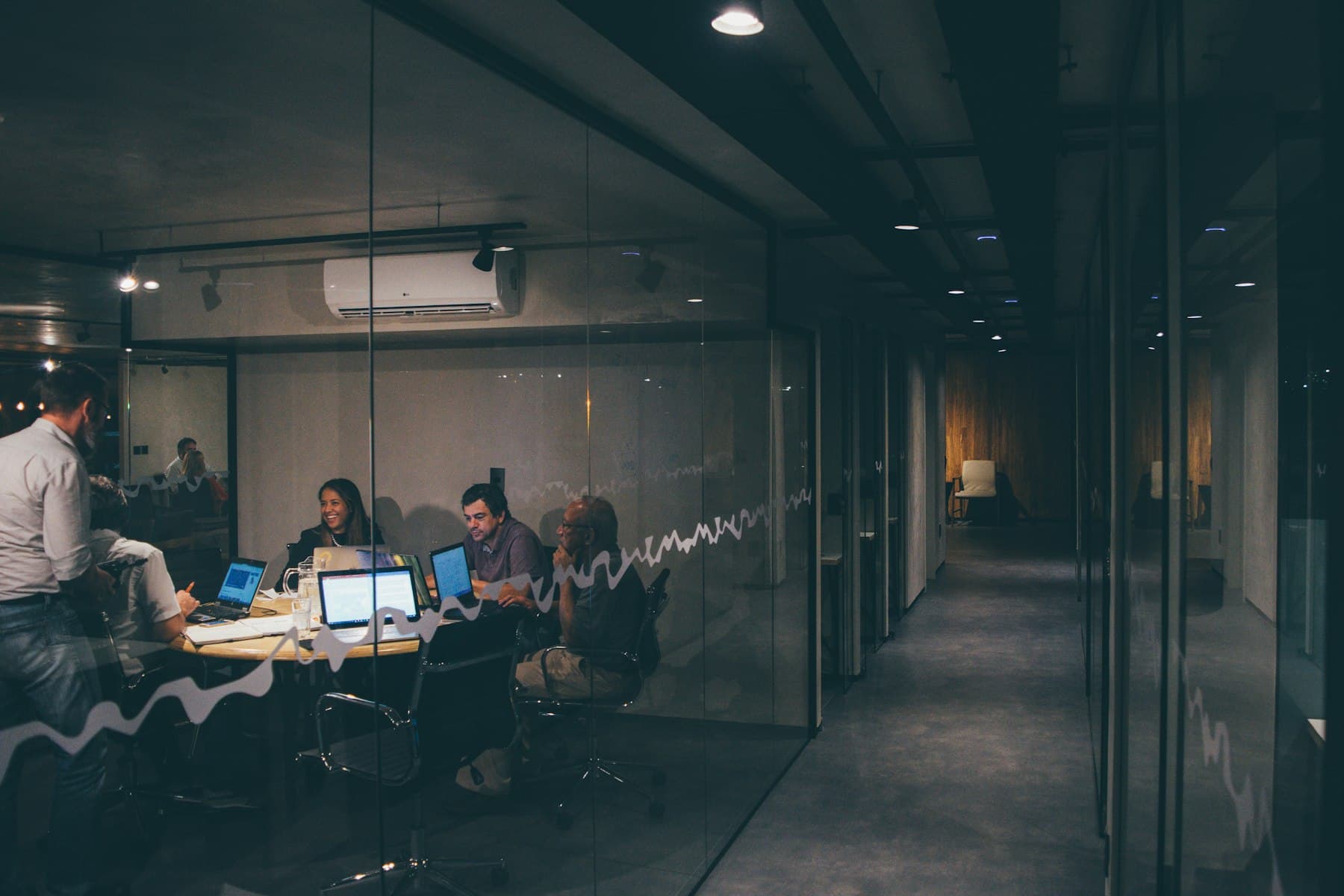 A corporate office corridor with glass meeting rooms